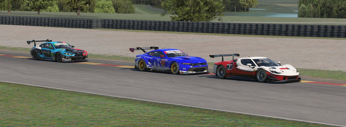 Three race cars, teal, blue, and white-and-red, lined up on track.